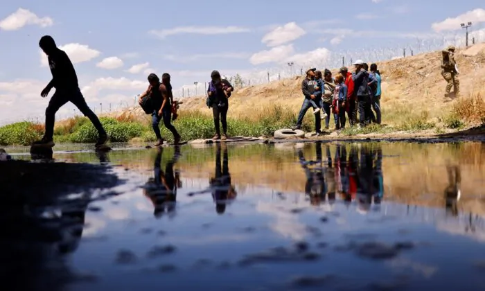 Những người nhập cư xin tị nạn băng qua sông Rio Bravo từ Hoa Kỳ để trở về Mexico, sau khi các thành viên Lực lượng Vệ binh Quốc gia Texas của Hoa Kỳ giăng dây thép gai để ngăn chặn người nhập cư vượt biên. Cảnh tượng được nhìn từ Ciudad Juarez, Mexico, hôm 13/05/2023. (Ảnh: Jose Luis Gonzalez/Reuters)