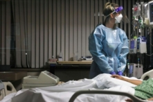 Một y tá đang kiểm tra màn hình trong một phòng bệnh. (Mario Tama/Getty Images)