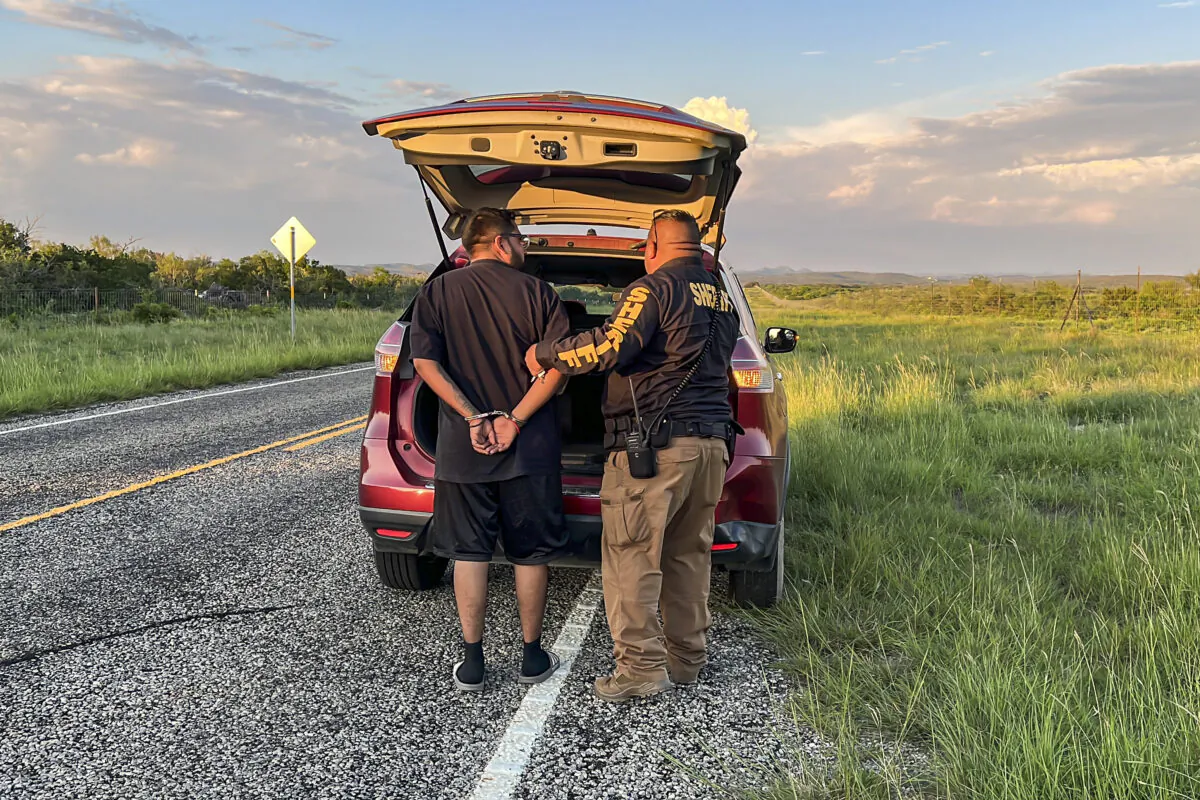 Một cảnh sát của Quận Kinney bắt giữ một người nhập cư bất hợp pháp đang được vận chuyển trái phép từ biên giới Hoa Kỳ-Mexico, qua Quận Kinney, Texas, vào ngày 10/09/2022. (Charlotte Cuthbertson/The Epoch Times)