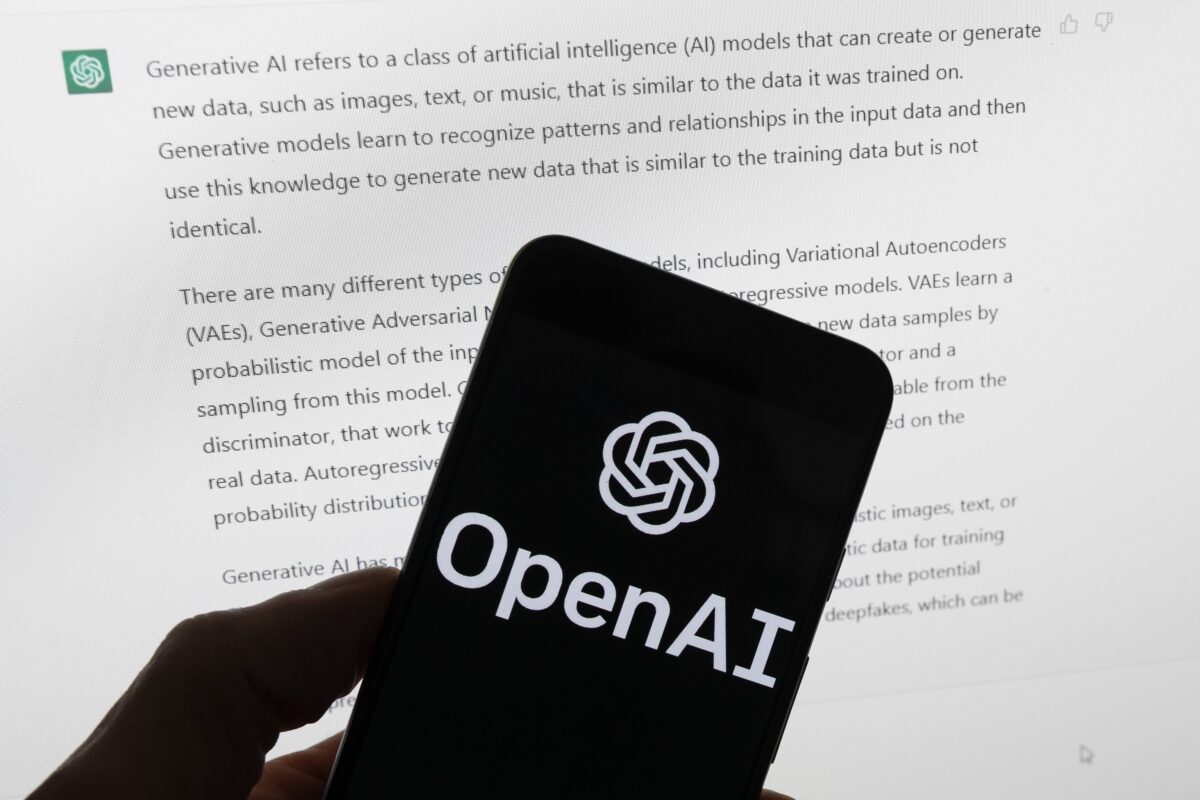 Logo OpenAI trên một chiếc điện thoại di động trước một màn hình máy điện toán hiển thị màn hình trang ChatGPT, ảnh chụp ở Boston hôm 21/03/2023. (Ảnh: Michael Dwyer/AP Photo)
