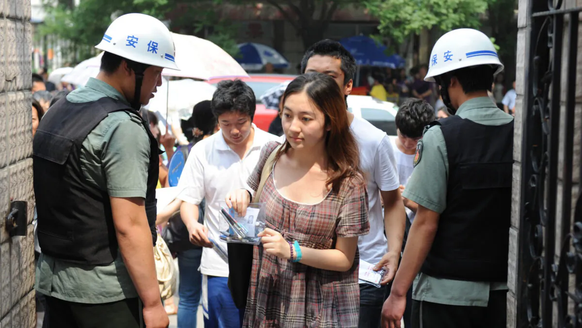 Nhân viên an ninh Trung Quốc kiểm tra danh tính của học sinh vào trường để tham gia kỳ thi tuyển sinh đại học đầy cam go hay còn gọi là Cao Khảo (Gaokao), ở Bắc Kinh, vào ngày 07/06/2012. (Ảnh: STR/AFP/GettyImages)