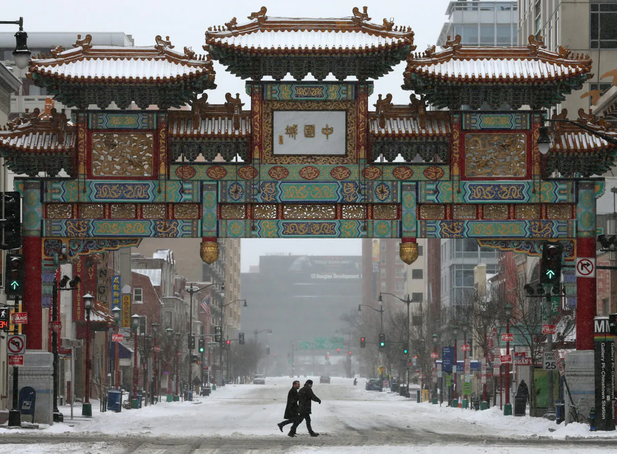Mọi người đi bộ dưới trời tuyết gần cổng khu phố Tàu, hay còn gọi là cổng Trung Hoa (China Gate), ở thủ đô Hoa Thịnh Đốn, vào ngày 03/03/2014. (Ảnh: Mark Wilson/Getty Images)