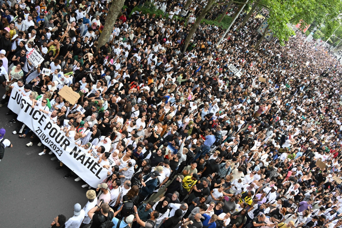 Những người tham dự cầm biểu ngữ có dòng chữ “Công lý cho Nahel” trong cuộc tuần hành tưởng niệm một người lái xe trẻ tuổi hôm 29/06/2023. (Ảnh: Bertrand Guay/AFP qua Getty Images)