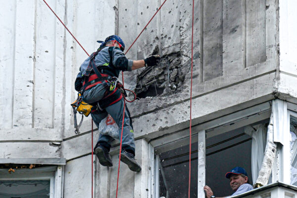 Một chuyên gia kiểm tra mặt tiền bị hư hại của một tòa nhà chung cư nhiều tầng sau một cuộc tấn công bằng phi cơ không người lái được ghi nhận ở Moscow hôm 30/05/2023. (Ảnh: Kirill Kudryavtsev/AFP qua Getty Images)
