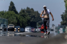 Một người đàn ông đi dọc con phố khi nhiệt độ tăng trên 100 độ F (38 độ C), ở thành phố Yuba, California, hôm 30/06/2023. (Ảnh: Carlos Barria/Reuters)