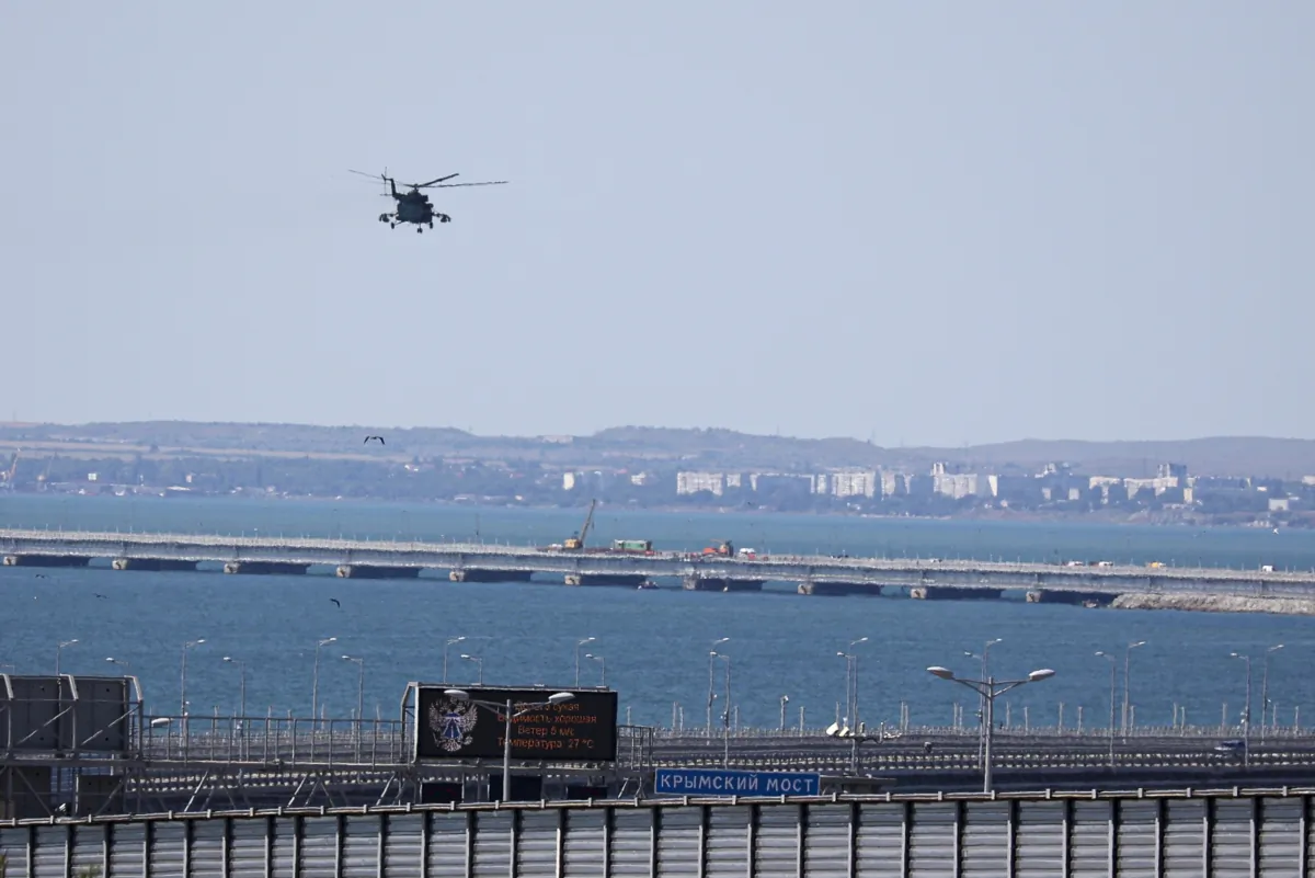 Một trực thăng quân sự của Nga bay qua các phần bị hư hỏng của một đoạn đường dành cho xe hơi trên Cầu Crimea nối đất liền của Nga và bán đảo Crimea qua Eo biển Kerch không xa Kerch, Crimea, hôm 17/07/2023. (Ảnh: AP Photo)