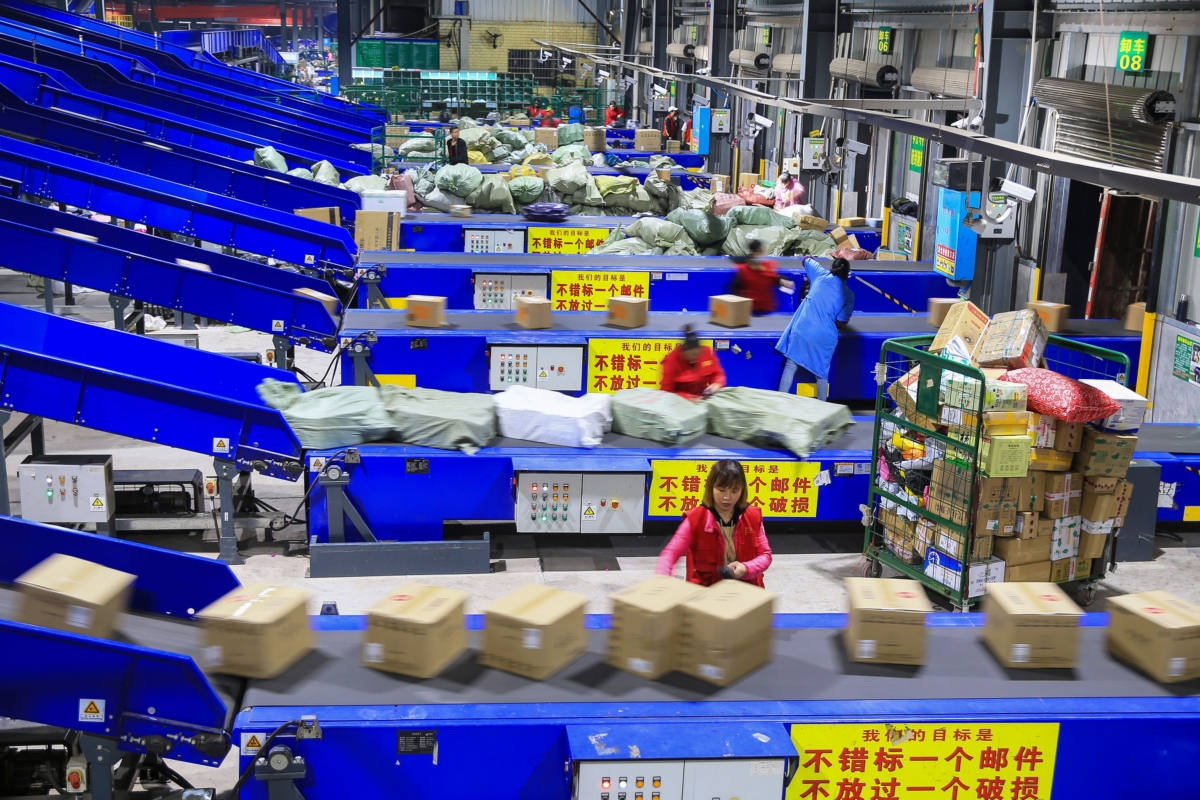 Công nhân phân loại các gói hàng tại một công ty giao hàng một ngày sau “Ngày Độc Thân,” sự kiện mua sắm kéo dài 24 giờ lớn nhất thế giới, ở Hành Dương thuộc tỉnh Hồ Nam, miền trung Trung Quốc sáng sớm ngày 12/11/2019. (Ảnh: STR/AFP qua Getty Images)