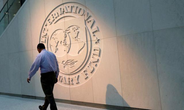 Một người đi ngang qua logo của Quỹ Tiền tệ Quốc tế (IMF) tại trụ sở chính ở Thủ đô Hoa Thịnh Đốn, vào ngày 10/05/2018. (Ảnh: Yuri Gripas/Reuters)