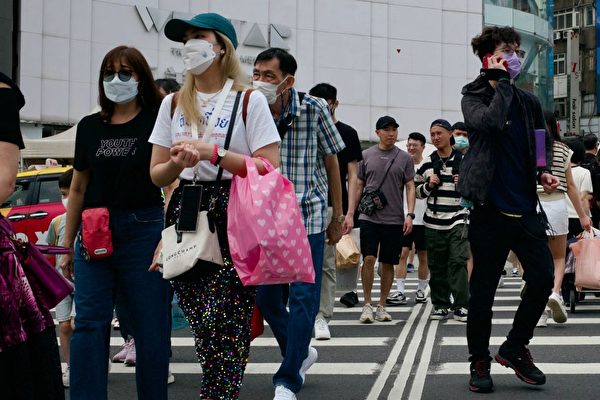 Thanh niên tản bộ trên đường phố Đài Bắc hôm 13/04/2023. (Ảnh: SAM YEH/AFP)