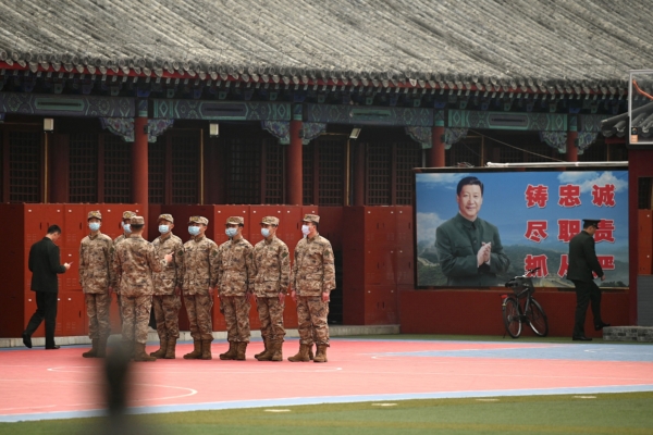Nhân viên an ninh đứng gác ở lối vào Tử Cấm Thành gần ảnh của lãnh đạo Trung Quốc Tập Cận Bình (Phải) tại Bắc Kinh vào ngày 11/03/2022. (Ảnh: Noel Celis/AFP qua Getty Images)