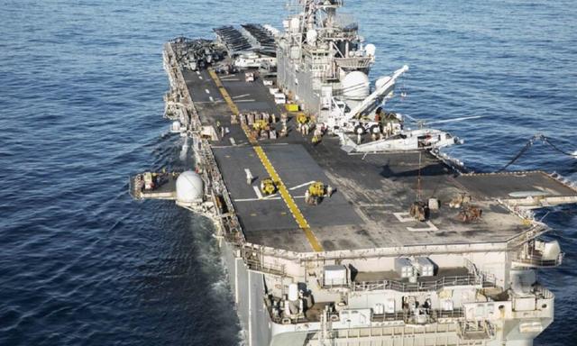 Một trực thăng MH-60S Sea Hawk, được phân công cho Dragon Whales thuộc Phi đội Trực thăng Chiến đấu Trên biển (HSC) 28, đang đặt hàng hóa lên sàn đáp của tàu tấn công đổ bộ lớp Wasp USS Bataan (LHD5) trong quá trình tiếp hàng thẳng đứng từ tàu USNS William McLean (T-AKE 12) chở hàng khô và đạn dược lên tàu Bataan, vào ngày 31/12/2019. (Ảnh: Hải quân Hoa Kỳ do Chuyên gia Truyền thông Đại chúng Cấp 1 Kathryn E. Macdonald thực hiện)