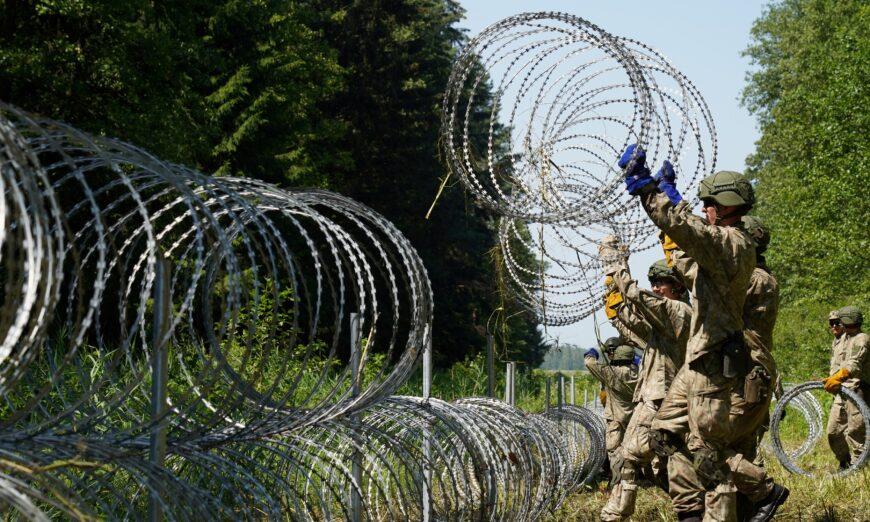 Các binh sĩ quân đội Lithuania đặt dây thép gai tại biên giới với Belarus ở Druskininkai, Lithuania, vào ngày 09/07/2021. (Ảnh: Janis Laizans/Reuters)