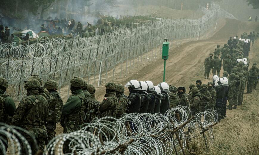 Binh lính và cảnh sát Ba Lan theo dõi những người nhập cư bất hợp pháp tại biên giới Ba Lan/Belarus gần Kuznica, Ba Lan, trong bức ảnh do Lực lượng Phòng vệ Lãnh thổ công bố, vào ngày 12/11/2021. (Ảnh: Irek Dorozanski/DWOT/qua Reuters)