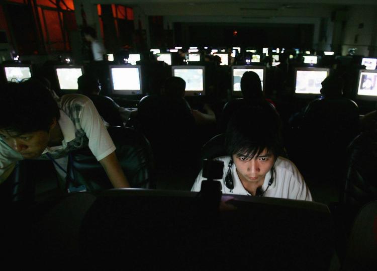 Một thanh niên đang ngồi trước máy điện toán trong quán cà phê mạng. (Ảnh: Cancun Chu/Getty Images)