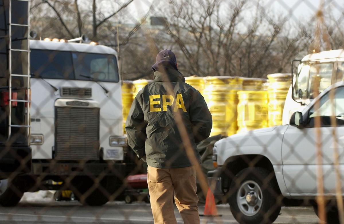 Một nhân viên EPA đi về phía các thùng 55 gallon trong một bãi đậu xe dành cho nhân viên gần tòa nhà Thượng viện Dirksen ở Hoa Thịnh Đốn vào ngày 04/02/2004. (Ảnh: Mannie Garcia/Getty Images)