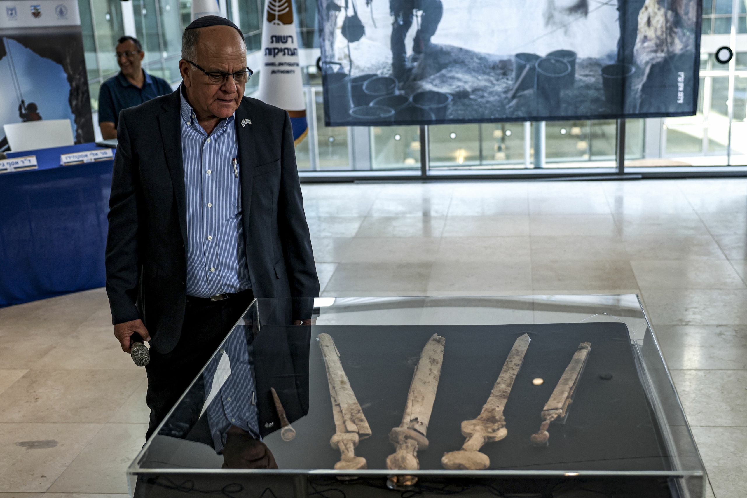 Ảnh chụp ông Eli Escusido, Cục trưởng IAA đang đứng cạnh tủ trưng bày di tích văn hóa. (Ảnh: Ronaldo Schemidt/AFP)