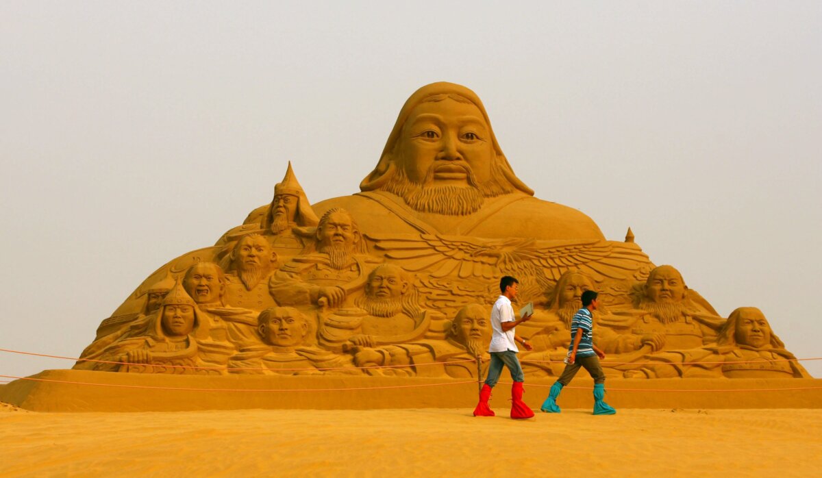Khách du lịch đi ngang qua tác phẩm điêu khắc bằng cát về Thành Cát Tư Hãn khi họ tham quan Xiangshawan, còn được gọi là Resonant Sand Bay (Cồn Cát Cộng Hưởng), ở Baton, Nội Mông Cổ, ngày 16/07/2007. (Ảnh: China Photos/Getty Images)