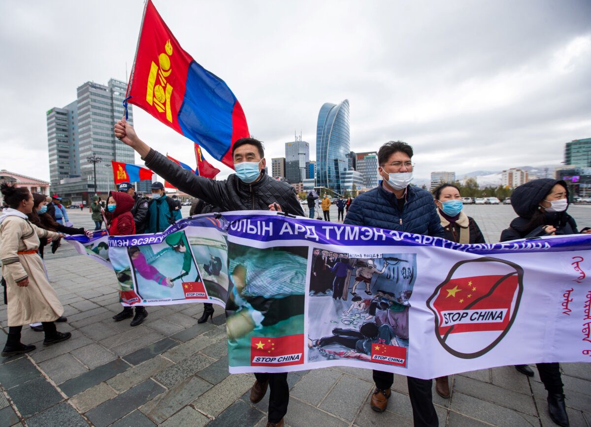 Những người biểu tình cầm biểu ngữ và vẫy cờ Mông Cổ trong cuộc biểu tình ở Ulaanbaatar, thủ đô của Mông Cổ, chống lại các chính sách của Trung Quốc ở tỉnh lân cận của Trung Quốc trong khu Nội Mông, Trung Quốc, ngày 01/10/2020. (Ảnh: Byambasuren Byamba-Ochir/AFP qua Getty Images)