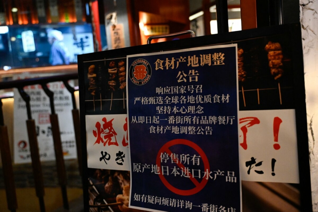 Một tấm biển ghi “Ngừng bán tất cả các sản phẩm cá nhập cảng từ Nhật Bản” tại một khu vực có nhiều nhà hàng Nhật Bản tại Bắc Kinh hôm 27/08/2023. (Ảnh: Pedro Pardo/AFP qua Getty Images)
