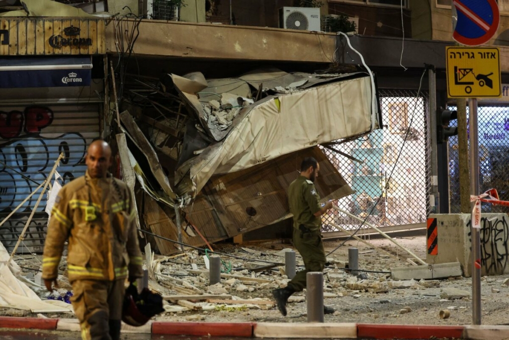 Một nhân viên cứu hộ đi lại trước một cửa hàng bị hư hại nặng nề tại Tel Aviv sau khi bị trúng hỏa tiễn của khủng bố Hamas phóng từ Dải Gaza, hôm 07/10/2023. (Ảnh: Jack Guez/Getty Images)