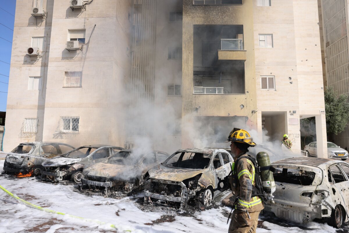 Các đội cứu hỏa Israel dập lửa tại bãi đậu xe bên ngoài một tòa nhà dân cư sau một vụ tấn công bằng hỏa tiễn từ Dải Gaza ở thành phố Ashkelon tại phía nam Israel hôm 07/10/2023. (Ảnh: Ahmad Gharabli/AFP qua Getty Images)