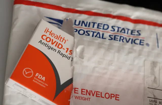 Các bộ xét nghiệm nhanh kháng nguyên COVID-19 miễn phí nhãn hiệu iHealth từ chính phủ liên bang nằm trên phong bì của Bưu điện Hoa Kỳ sau khi được giao tại San Anselmo, California, vào ngày 04/02/2022. (Ảnh: Justin Sullivan/Getty Images)