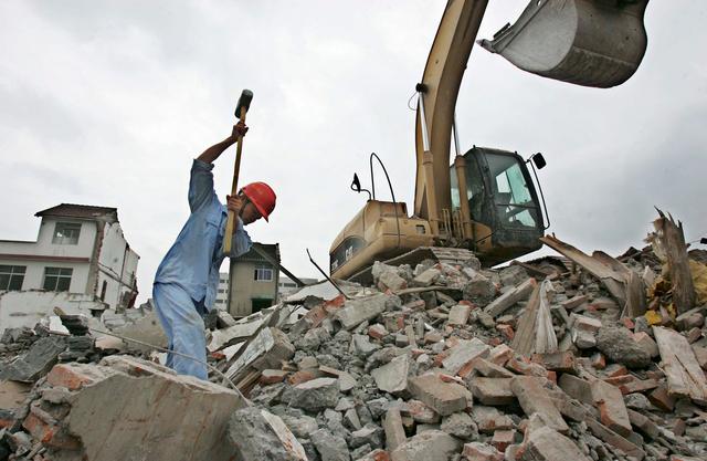 Một người đàn ông làm việc tại một địa điểm phá hủy ở khu Bạch Liên Kính ở Quận Phố Đông, nơi những ngôi nhà dân cư đang bị phá hủy ở Thượng Hải, Trung Quốc, vào ngày 28/08/2005. (Ảnh: China Photos/Getty Images)