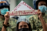 Một người biểu tình cầm chiếc thuyền giấy có dòng chữ “bảo vệ Biển Tây Philippine” trong cuộc biểu tình bên ngoài Lãnh sự quán Trung Quốc ở khu tài chính Manila, thủ đô Philippines, ngày 12/07/2021. (Ảnh: Eloisa Lopez/Reuters)