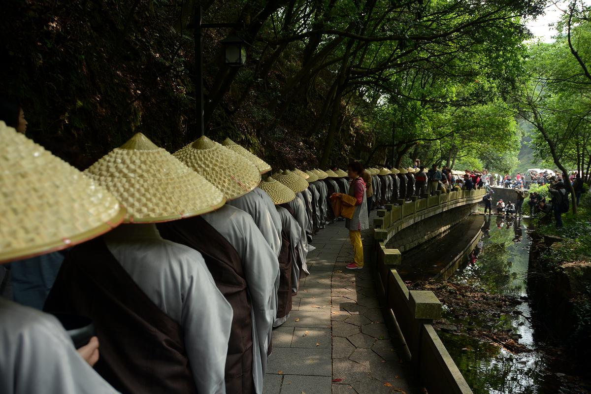 Các tăng ni Phật giáo của Chùa Linh Ẩn đi bộ để nhận lễ vật của Phật tử trong một sự kiện từ thiện kỷ niệm ngày đản sinh Đức Thích Ca Mâu Ni, nhà sáng lập Phật giáo, tại Hàng Châu, tỉnh Chiết Giang, Trung Quốc, vào ngày 25/05/2015. (Ảnh: VCG/VCG qua Getty Images)