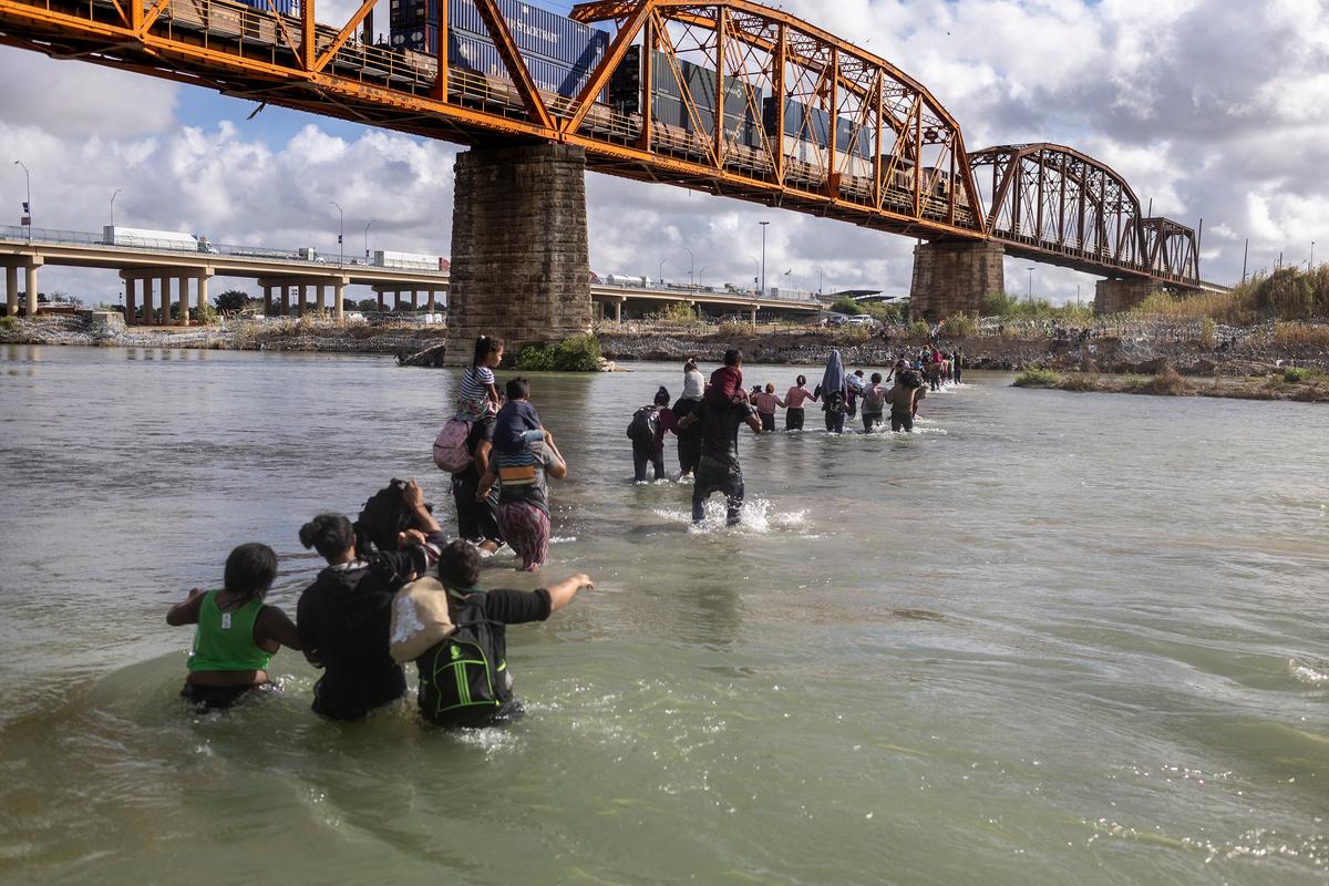Những người nhập cư bất hợp pháp băng qua sông Rio Grande từ Mexico vào Hoa Kỳ, ở Eagle Pass, Texas, hôm 30/09/2023. (Ảnh: John Moore/Getty Images)