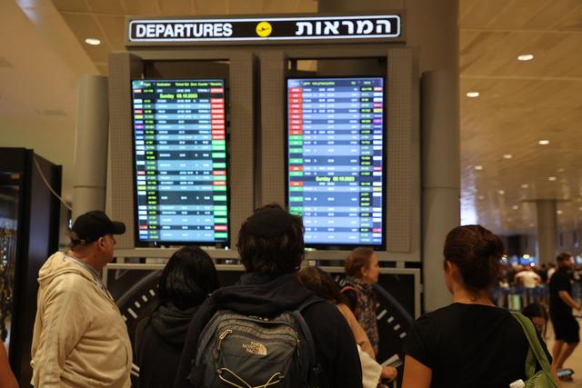 Hành khách đang xem một bảng điện tử hiển thị thông tin chuyến bay tại Phi trường Ben Gurion gần Tel Aviv, Israel, hôm 07/10/2023, khi các chuyến bay bị hủy vì các cuộc tấn công bất ngờ của Hamas. (Ảnh: Gil Cohen-Magen/AFP qua Getty Images)