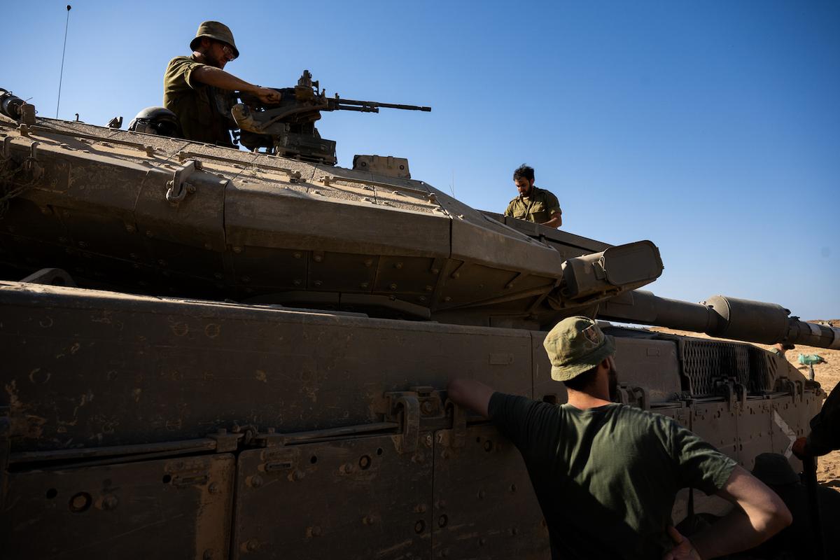 Các binh sĩ của Lực lượng Phòng vệ Israel đang lau chùi các bộ phận của một chiếc xe tăng, ở miền Nam Israel, hôm 21/10/2023. (Ảnh: Alexi J. Rosenfeld/Getty Images)