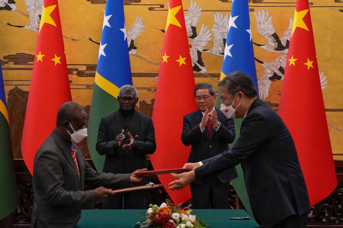 Thủ tướng Quần đảo Solomon Manasseh Sogavare (thứ 2 bên trái) và Thủ tướng Trung Quốc Lý Cường (thứ 2 bên phải) vỗ tay khi quan chức của cả hai quốc gia trao đổi các văn bản đã ký tại Đại lễ đường Nhân dân ở Bắc Kinh hôm 10/07/2023. (Ảnh: Andy Wong/Pool/AFP qua Getty Images)