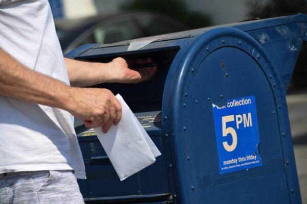 Một người bỏ thư vào hộp thư bên ngoài bưu điện ở Los Angeles, California, vào ngày 17/08/2020. (Ảnh: Robyn Beck/AFP qua Getty Images)