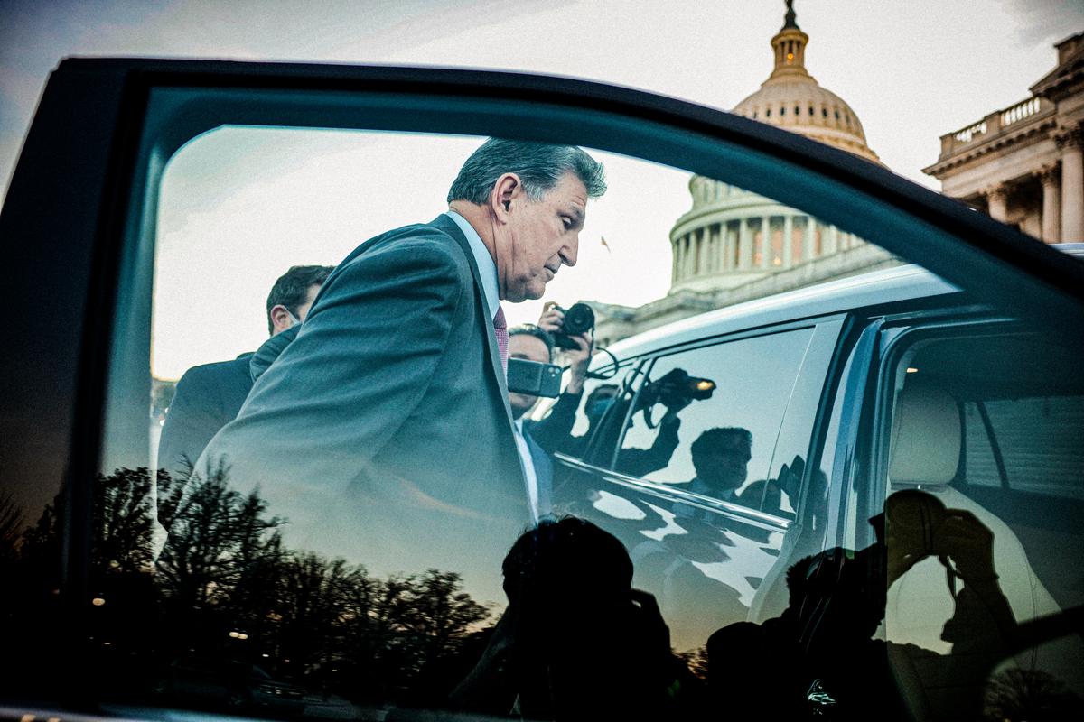 Theo sau là các phóng viên, Thượng nghị sĩ Joe Manchin (Dân Chủ-West Virginia) đi bộ đến xe hơi của ông sau khi tham gia một cuộc bỏ phiếu tại Tòa nhà Capitol ở Hoa Thịnh Đốn, vào ngày 14/12/2021. (Ảnh: Anna Moneymaker/Getty Images)