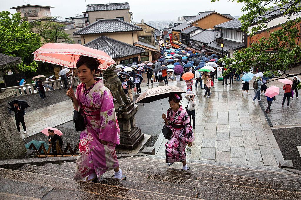 Du khách mặc yukata, một loại kimono nhẹ mặc mùa hè, không có vải lót, làm bằng vải cotton thay vì lụa truyền thống, leo lên các bậc thang để viếng thăm một ngôi chùa vào ngày 27/04/2016, ở Kyoto, Nhật Bản. (Ảnh: Carl Court/Getty Images)