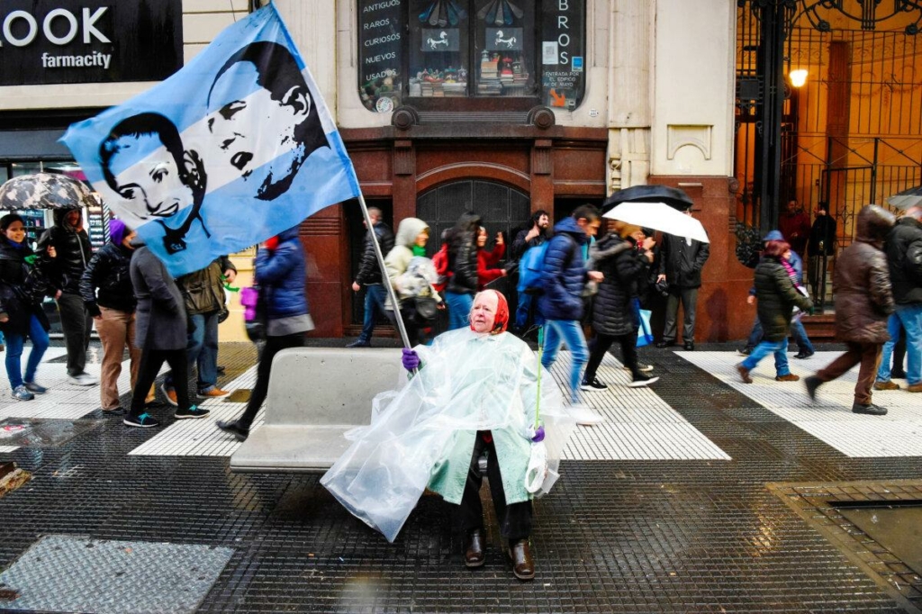 Một người phụ nữ vẫy lá cờ có hình vị tổng thống ba nhiệm kỳ của Argentina Juan Domingo Peron và vợ ông, bà Eva Peron, trong cuộc tuần hành đòi tăng lương cho giáo viên và phản đối việc cắt giảm ngân sách tại các trường đại học công lập Argentina, ở Buenos Aires, Argentina, vào ngày 30/08/2018. (Ảnh: Eitan Abramovich/AFP qua Getty Images)