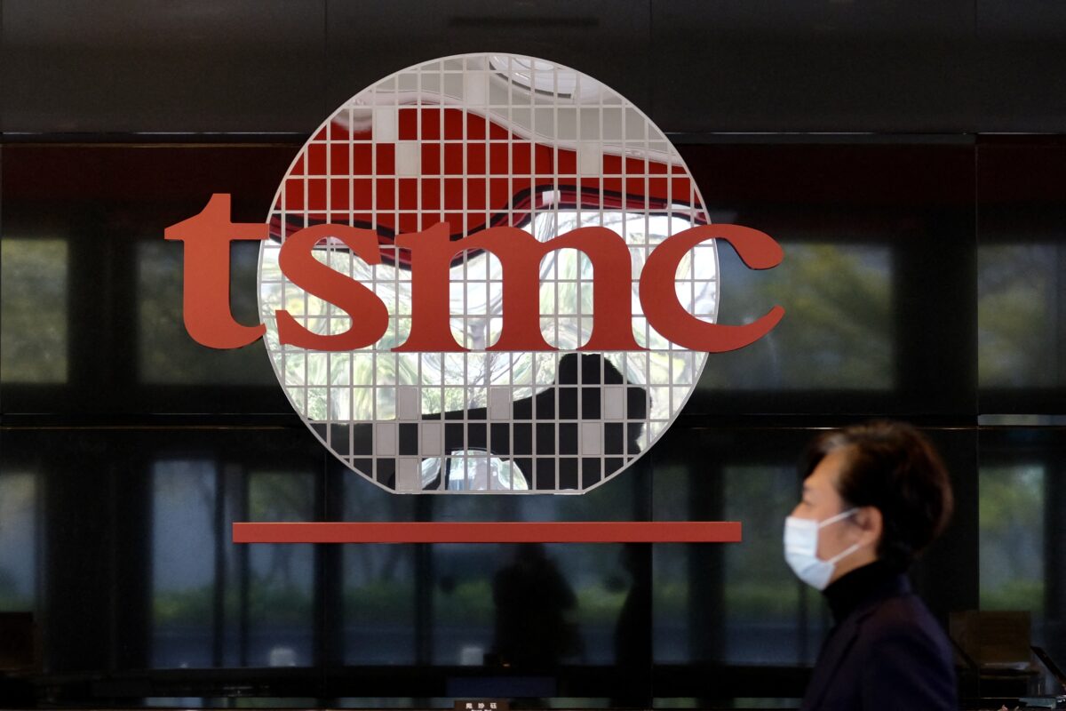 Một người đàn ông đi ngang qua một biểu tượng công ty tại trụ sở của nhà sản xuất chất bán dẫn lớn nhất thế giới, TSMC, ở Tân Trúc, Đài Loan, vào ngày 29/01/2021. TSMC đã bắt đầu xây dựng một nhà máy bán dẫn ở Arizona. (Ảnh: Sam Yeh/AFP qua Getty Images)