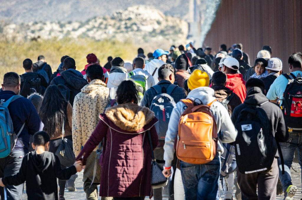 Những người nhập cư bất hợp pháp đã đi qua một khoảng trống trên bức tường biên giới Hoa Kỳ, và họ đang chờ các nhân viên Tuần tra Biên giới đến giải quyết, ở Jacumba, California, hôm 07/12/2023. (Ảnh: John Fredricks/The Epoch Times)