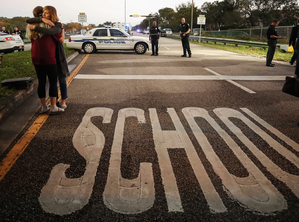 Hai người phụ nữ ôm nhau tại trạm kiểm soát của cảnh sát gần trường trung học Marjory Stoneman Douglas, nơi 17 người thiệt mạng một ngày trước đó, ở Parkland, Florida vào ngày 15/02/2018. (Ảnh: Mark Wilson/Getty Images)