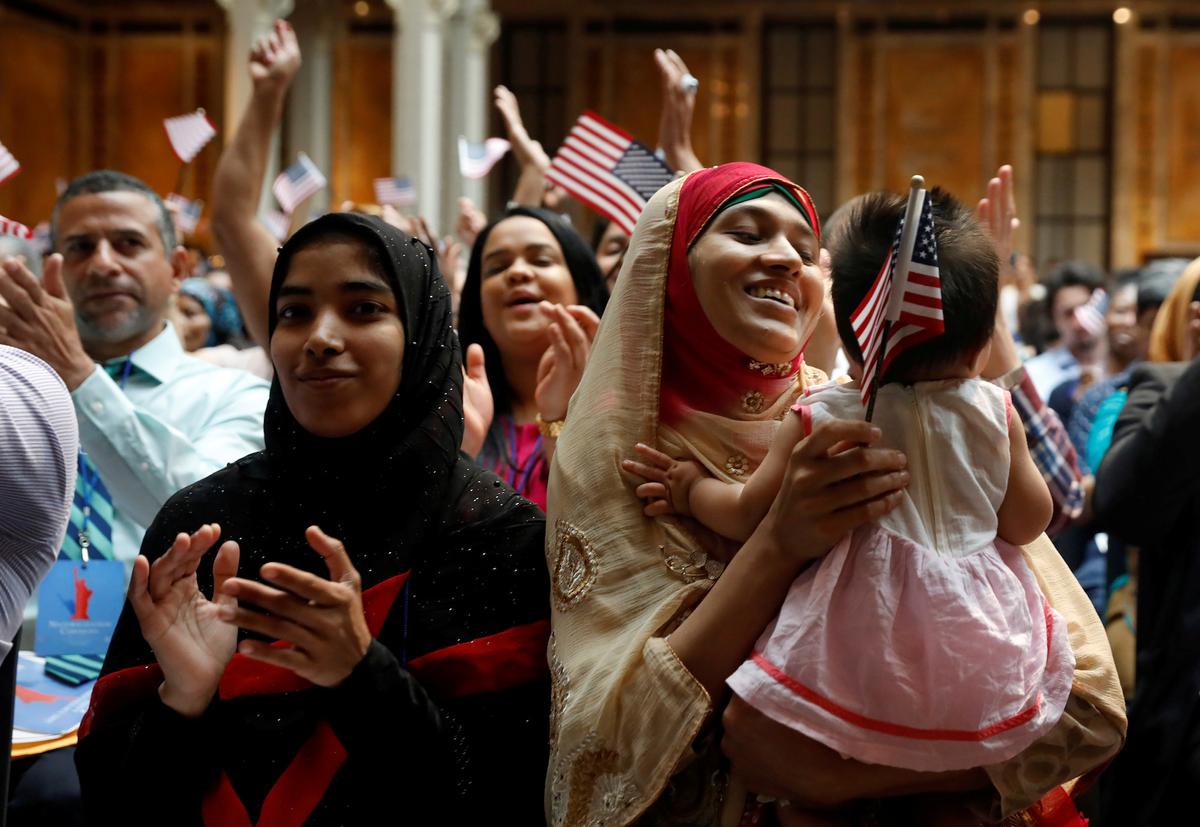 Những công dân mới mỉm cười trong buổi lễ nhập quốc tịch của Cơ quan Di trú và Nhập tịch Hoa Kỳ (USCIS) tại Thư viện Công cộng New York ở Manhattan, New York, vào ngày 03/07/2018. (Ảnh: Shannon Stapleton/Reuters)