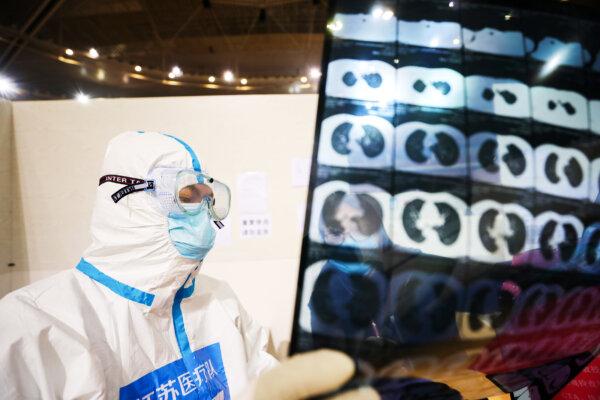 Một bác sĩ xem bản chụp CT của bệnh nhân tại một bệnh viện tạm thời được dựng lên dành cho bệnh nhân COVID-19 tại một sân vận động thể thao ở Vũ Hán, tỉnh Hồ Bắc, miền Trung Trung Quốc ngày 05/03/2020. (Ảnh: STR/AFP qua Getty Images)