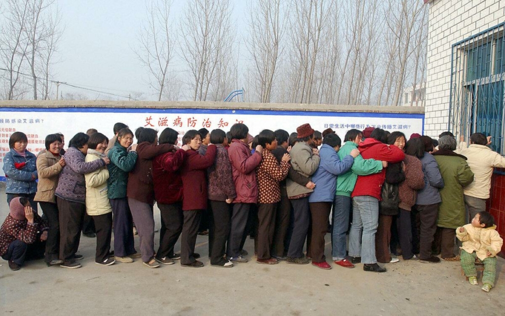 Những người nông dân Trung Quốc xếp hàng tại một phòng khám địa phương để nhận thuốc điều trị AIDS miễn phí ở làng Wenlou, tỉnh Hà Nam, Trung Quốc, vào ngày 21/02/2004. (Ảnh: STR/AFP qua Getty Images)