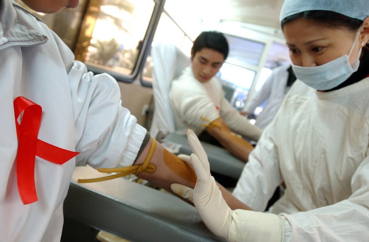 Một y tá chuẩn bị lấy máu từ người hiến trong chiến dịch hiến máu tình nguyện nhân Ngày AIDS Thế giới ở Thành Đô, Trung Quốc, vào ngày 01/12/2005. (Ảnh: China Photos/Getty Images)
