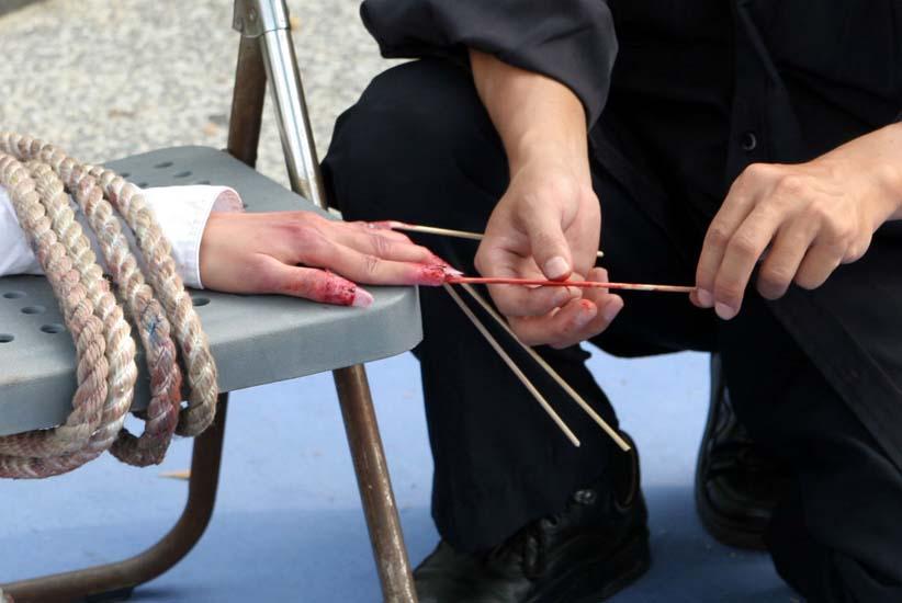 Tái hiện chiếc tăm đâm vào dưới móng tay. (Ảnh được đăng dưới sự cho phép của Minghui.org)