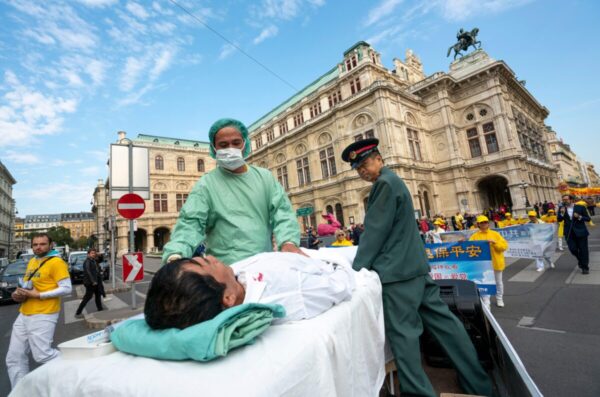 Các học viên Pháp Luân Công tái hiện cảnh các học viên bị cầm tù ở Trung Quốc bị thu hoạch nội tạng, trong cuộc biểu tình ở Vienna, vào ngày 01/10/2018. (Ảnh: Joe Klamar/AFP qua Getty Images)