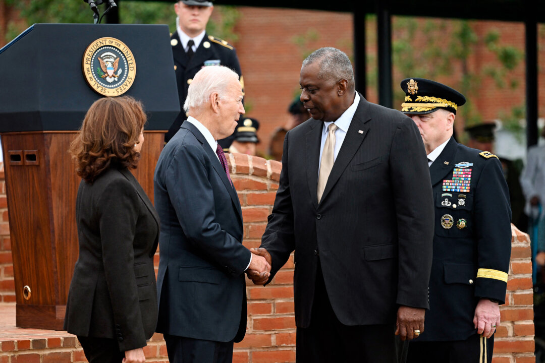 Tổng thống Joe Biden (ở giữa) bắt tay Bộ trưởng Quốc phòng Lloyd Austin, khi Phó Tổng thống Kamala Harris đứng bên cạnh, ở Arlington, Virginia, hôm 29/09/2023. (Ảnh: Saul Loeb/AFP qua Getty Images)