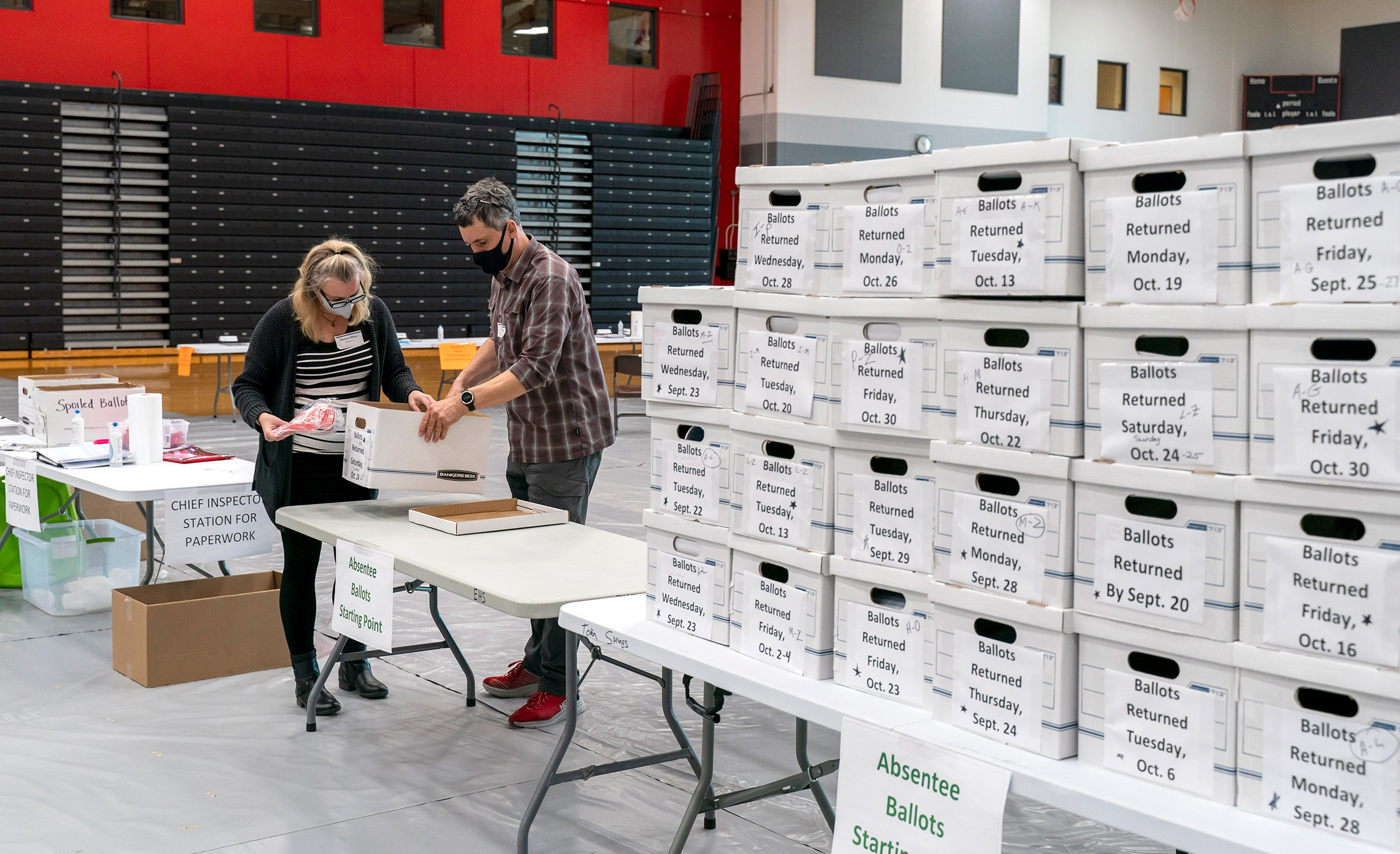 Nhân viên phòng phiếu kiểm tra thùng phiếu bầu khiếm diện trong phòng tập thể dục tại trường Trung học Sun Prairie ở Sun Prairie, Wisconsin, vào ngày 03/11/2020. (Ảnh: Andy Manis / Getty Images)