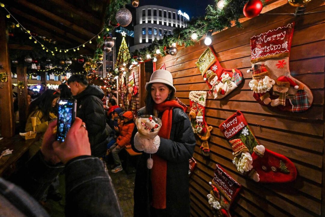 Người dân ghé thăm chợ Giáng Sinh ở quận Hoàng Phố, Thượng Hải hôm 23/12/2023. (Ảnh: Hector Retamal/AFP qua Getty Images)