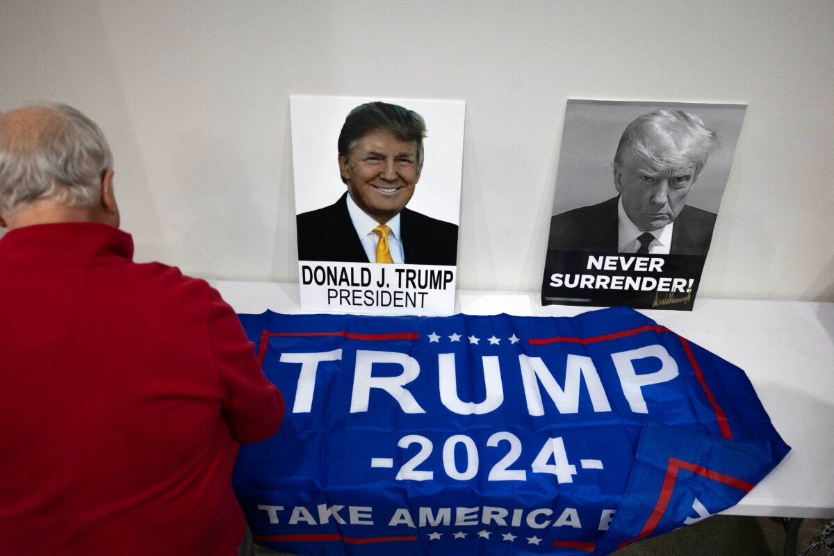 Một người đàn ông đặt lá cờ có tên ông Trump lên bàn khi chờ đợi Dân biểu Marjorie Taylor Greene (Cộng Hòa-Georgia) đến dự một sự kiện tranh cử ở Keokuk, Iowa, hôm 04/01/2024. (Ảnh: Christian Monterrosa/AFP qua Getty Images )